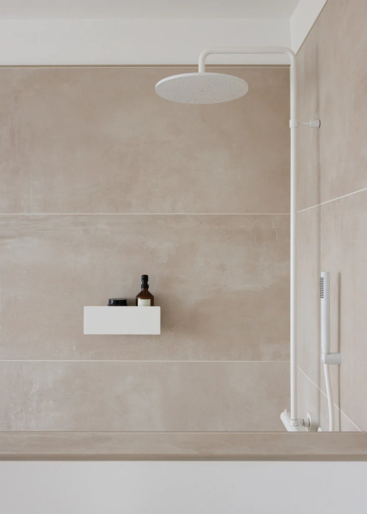 Hvid brusehylde der limes på væg